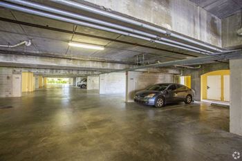 View of parking garage with a parked gray vehicle
